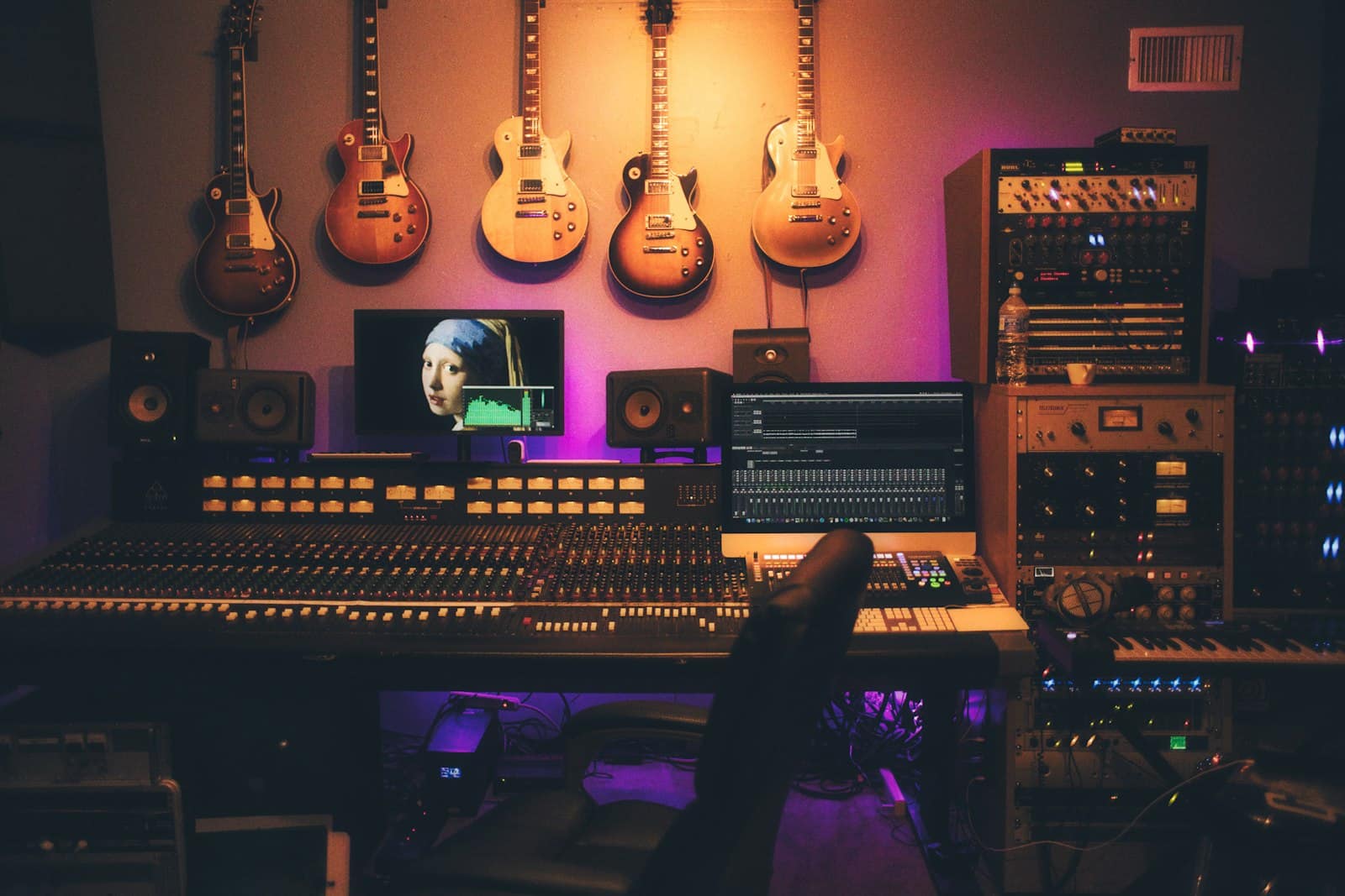 Estudio de grabación con mesa de mezclas, monitores y guitarras